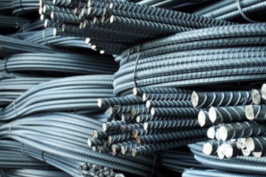 Stacks of bundled steel rebar coils in a warehouse storage yard.